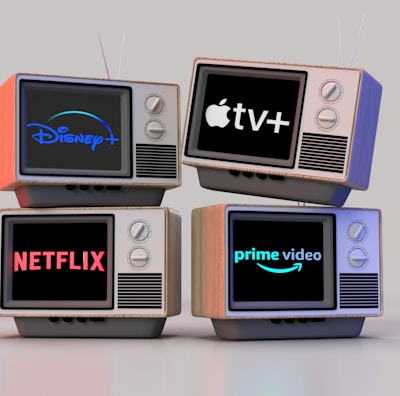 Four old-style television sets are stacked in two rows and each screen displays a different streaming service logo: Disney+, Apple TV+, Netflix, and Prime Video.